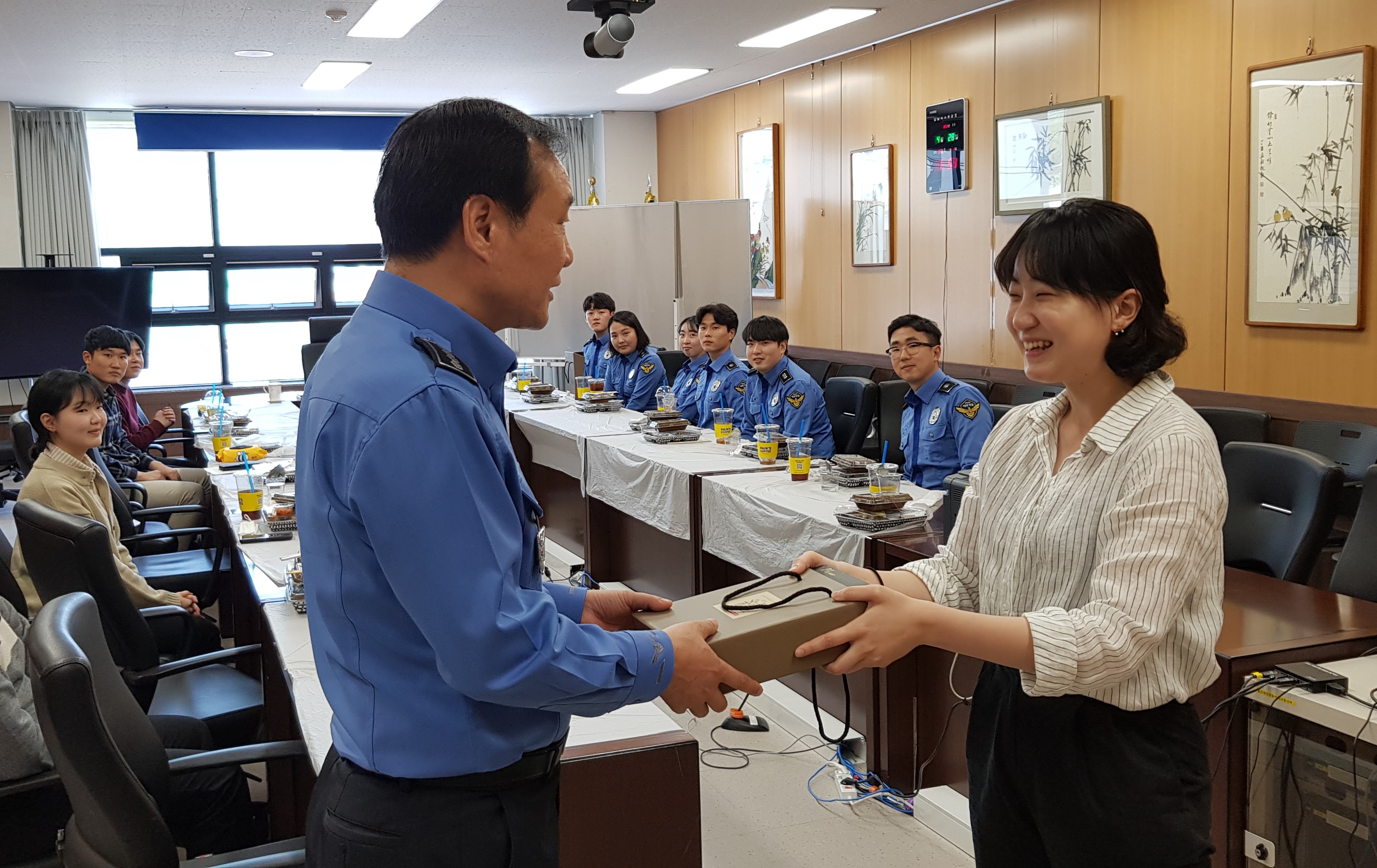 울진해경서장이 개선사항을 발표한 새내기 경찰관에게 기념품을 주고 있다