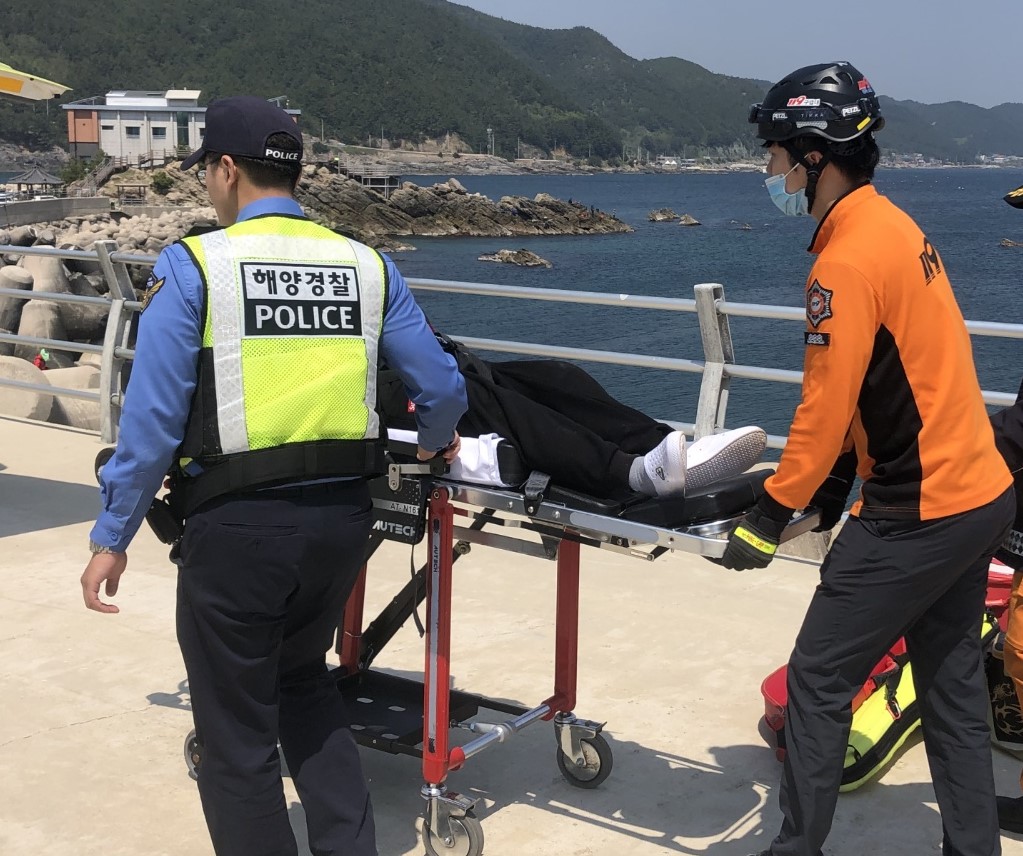 방파제에 추락한 낚시객을 구조하여 이송하고 있다