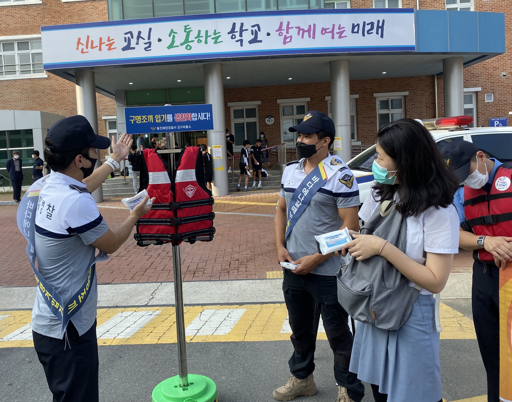 울진해경 강구파출소에서 경찰관이 중고등학교 청소년에게 구명조끼에 대한 설명을 하고있다