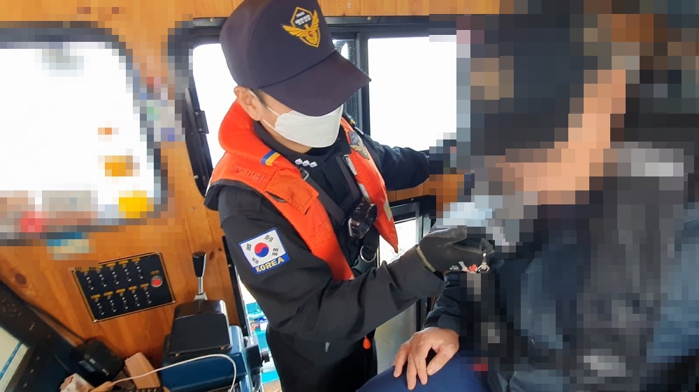 군산해경이 낚시어선 선장을 상대로 음주측정을 실시하고 있다