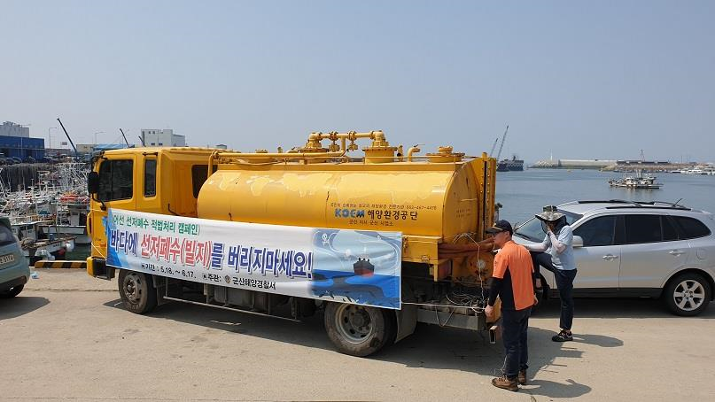 군산해경이 해양환경공단과 합동으로 선저폐수를 수거하고 있다.