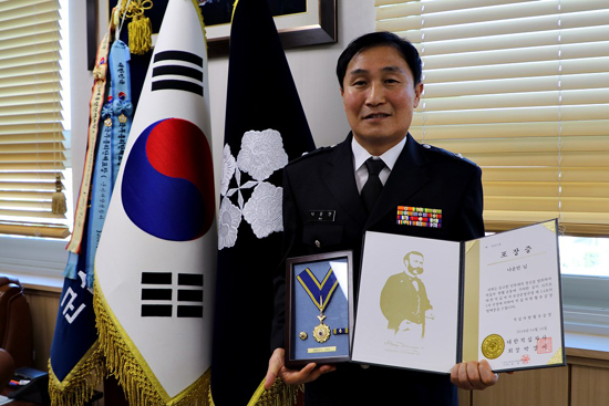 군산해경 개야도파출소장 나윤만 경위가 대한적십자사로부터 명예장 포장증을 받고 기념 촬영을 하고 있다.