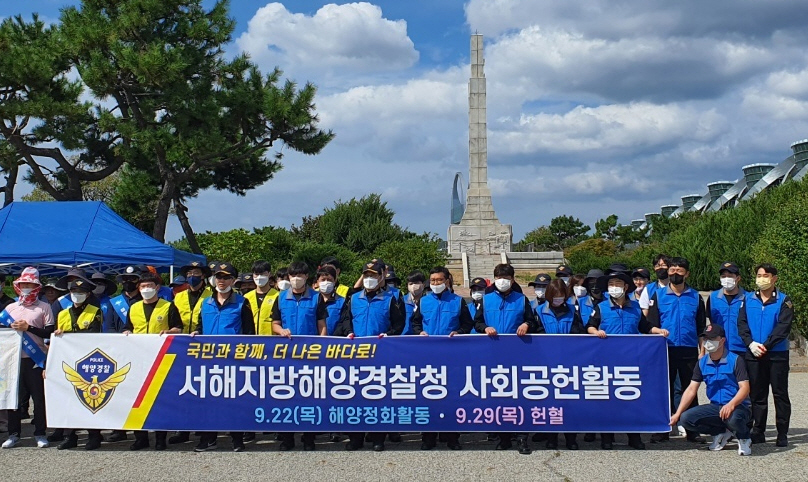 서해지방해양경찰청 경찰관들이 22일 전남 영암군 대불부두~영산강 하굿둑 배수갑문 일원에서 연안정화활동을 한 뒤 기념촬영을 하고 있다.